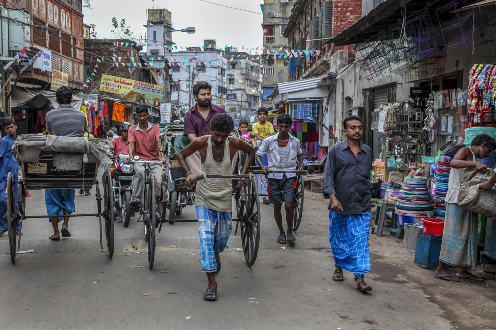 Indien, India, Kalkutta, Kolkata, street photography,travel, reisereportage, fotografie, fotoausstellung, reportage, fotoreportage, Menschen, Leben, Straße, Verkehr, Rikscha Verkehrschaos, Laufrikscha, Stadt der Freude, Mensch zieht Rikscha,